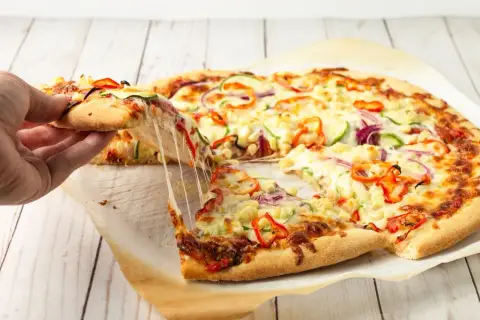 Idealne proporcje ciasta na pizzę, z ciągnącym się serem i kolorowymi warzywami. Idealna na wspólne chwile.